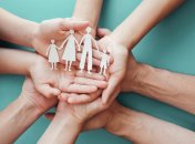 Adult and children hands holding paper family cutout, family home,adoption foster care, homeless charity, family mental health,  homeschool education, domestic violence, social distancing, isolation