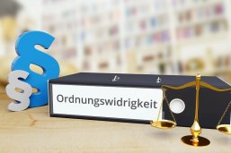Ordnungswidrigkeit – Recht/Gesetz. Ordner auf Schreibtisch mit Beschriftung neben Paragraf und Waage. Anwalt Ordnungswidrigkeit – Recht/Gesetz. Ordner auf Schreibtisch mit Beschriftung neben Paragraf und Waage. Anwalt